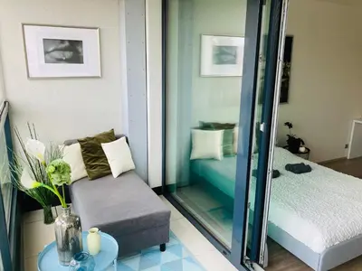 a living room with a chair and a mirror at Apartement Blanc Harfa design in Prague
