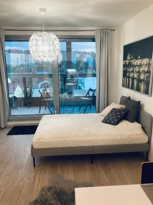 a living room with a bed and a large window at Apartement Blanc Harfa design in Prague