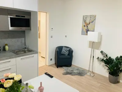 a kitchen with a table and a chair in a room at Apartement Blanc Harfa design in Prague