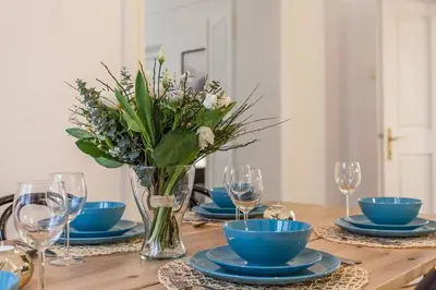 a table with blue plates and a vase of flowers at Old Town 2 BDR apartment, free coffee in Prague