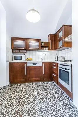 a kitchen with wooden cabinets and a tile floor at Old Town 2 BDR apartment, free coffee in Prague