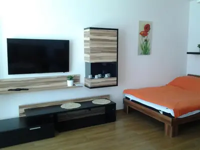 a bedroom with a bed and a flat screen tv at Apartmán Residence Nábřeží in Beroun