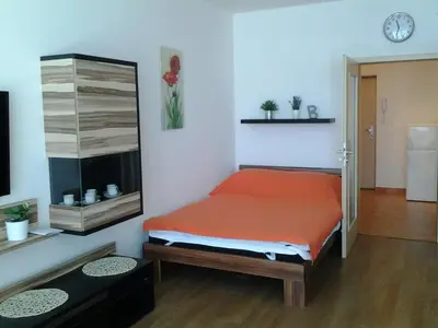 a bedroom with a bed and a clock on the wall at Apartmán Residence Nábřeží in Beroun