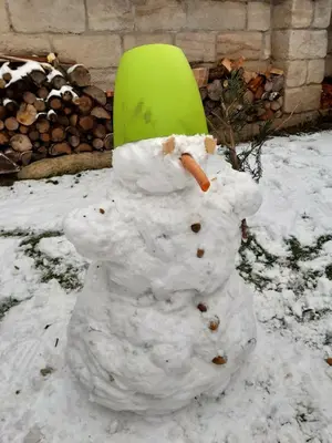 a snowman with a green hat on its head at Roubenka u Huvarů in Tachov