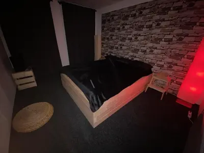 a bedroom with a bed and a brick wall at WELLNESS APARTMÁN KAROLÍNA in Milovice