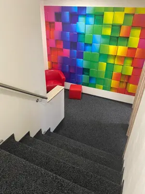 a room with a colorful wall and a staircase at WELLNESS APARTMÁN KAROLÍNA in Milovice