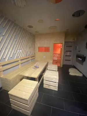 a room with two benches and a table in it at WELLNESS APARTMÁN KAROLÍNA in Milovice