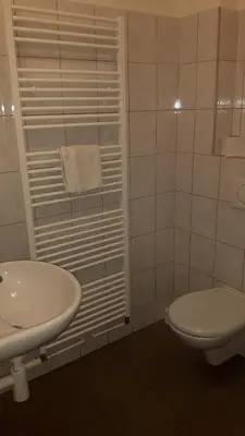 a white bathroom with a toilet and a sink at Ubytovna Koupaliště in Litoměřice