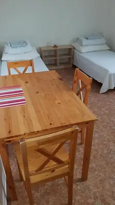 a wooden table and chairs in a room with two beds at Ubytovna Koupaliště in Litoměřice