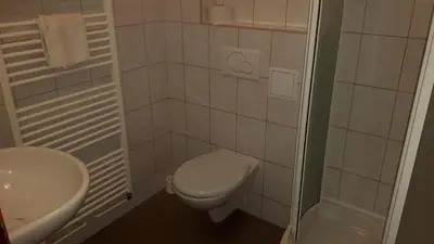 a white bathroom with a toilet and a sink at Ubytovna Koupaliště in Litoměřice
