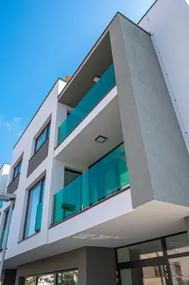 a white building with glass windows on it at Grunt Apartments in Mladá Boleslav