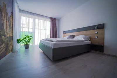 a bedroom with a large bed and a large window at Grunt Apartments in Mladá Boleslav