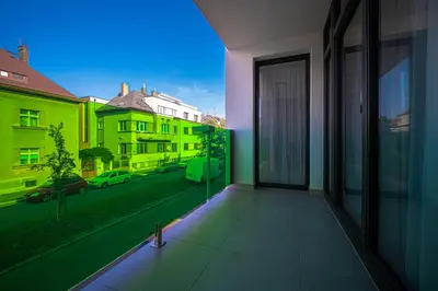 a balcony with a view of a street with buildings at Grunt Apartments in Mladá Boleslav