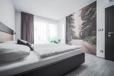 a bedroom with a bed with a painting on the wall at Grunt Apartments in Mladá Boleslav