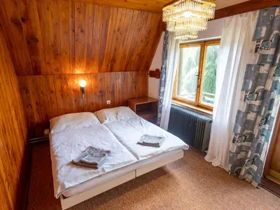 a bedroom with a bed with a wooden wall at Holiday Home Jestřebice 8 by Interhome in Dobřeň