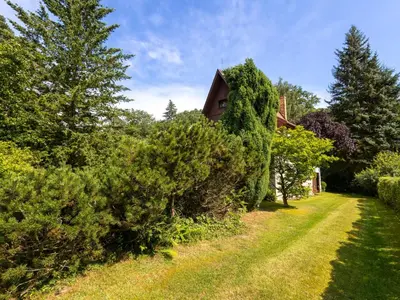 a garden with bushes and a house in the background at Holiday Home Jestřebice 8 by Interhome in Dobřeň
