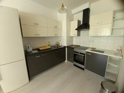 a kitchen with white cabinets and black appliances at apartment golden Prague in Prague
