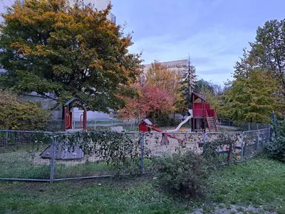 a playground behind a fence in a park at apartment golden Prague in Prague