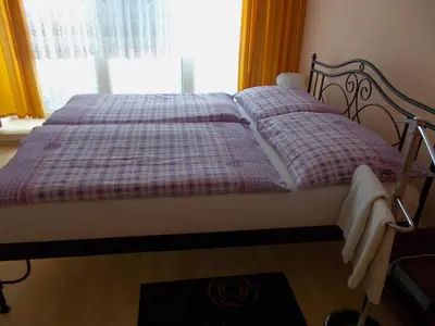 a bed with a checkered blanket and a window at soukromý pokoj in Prague
