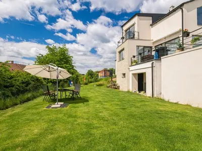 a patio with an umbrella and a table on a lawn at Apartment Lány by Interhome in Lány