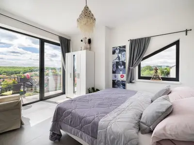a bedroom with a large bed and large windows at Apartment Lány by Interhome in Lány