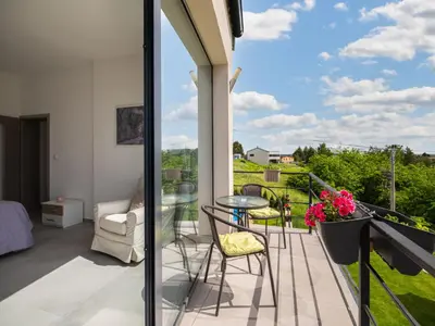 a balcony with a glass table and chairs at Apartment Lány by Interhome in Lány