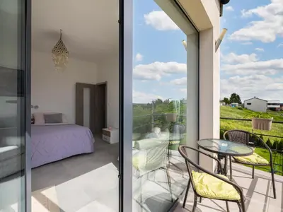 a bedroom and a balcony with a bed and a table at Apartment Lány by Interhome in Lány
