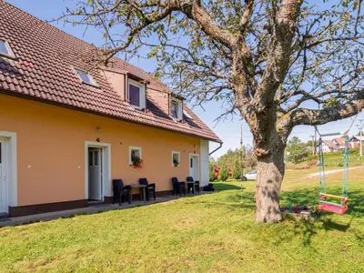 a house with a tree and a swing at Apartment Rabyně-1 by Interhome in Rabyně