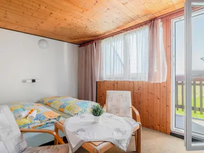 a room with two beds and a table and chairs at Apartment Rabyně-1 by Interhome in Rabyně