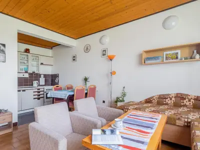 a living room with a table and a kitchen at Apartment Rabyně-1 by Interhome in Rabyně