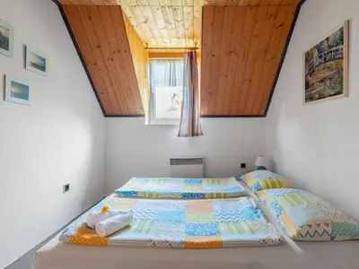 a bed with a quilt on it in a bedroom at Apartment Rabyně-1 by Interhome in Rabyně