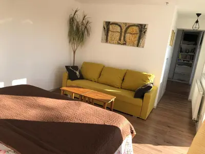 a living room with a yellow couch and a table at Apartmán - D - Vyhlídka nad řekou in Zdiby