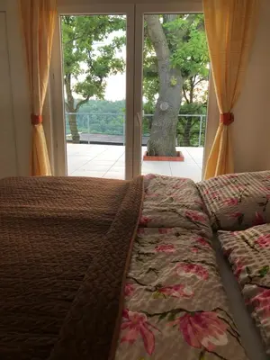 a bed in front of a window with a view at Apartmán - D - Vyhlídka nad řekou in Zdiby