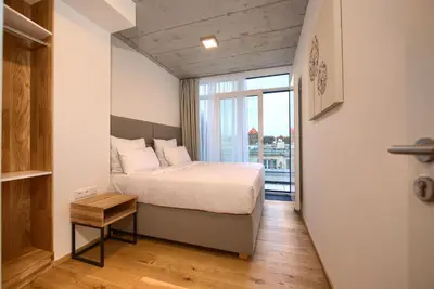 a bedroom with a bed and a large window at Residence Soukenicka in Prague