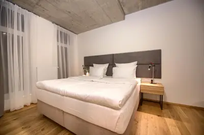 a bedroom with a large white bed and a wooden floor at Residence Soukenicka in Prague