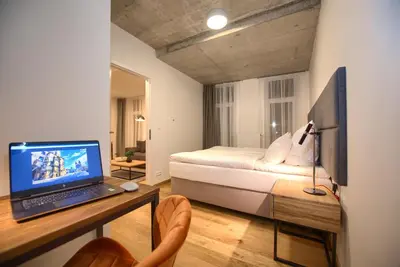 a bedroom with a bed and a laptop on a desk at Residence Soukenicka in Prague