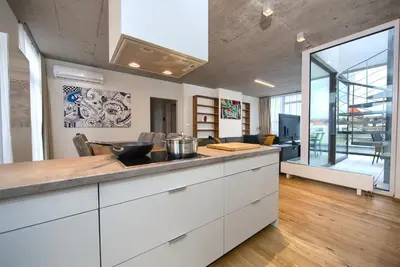 a kitchen with white cabinets and a large window at Residence Soukenicka in Prague