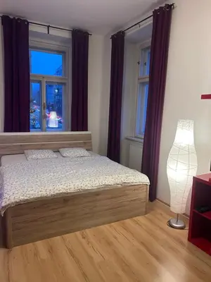a bedroom with a bed and a lamp and windows at Just BE that´s enough!! in Prague