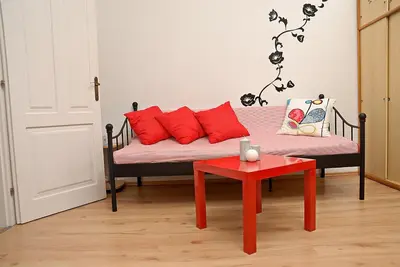 a couch with red pillows and a red table at Just BE that´s enough!! in Prague