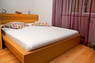 a bed with white sheets and pillows in a bedroom at Just BE that´s enough!! in Prague