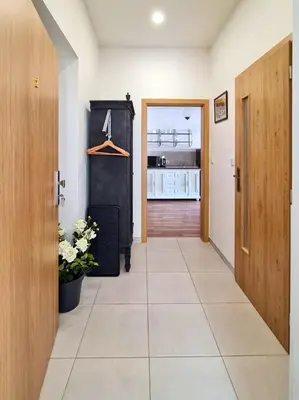 a hallway with a closet and a door and a tile floor at Apartmán Praha Břevnov in Prague