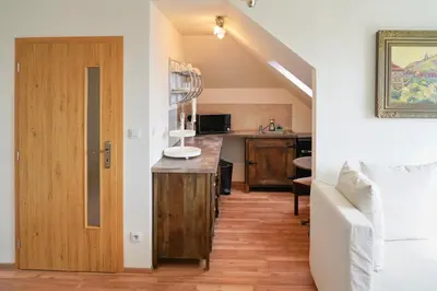 a kitchen with a wooden floor and a door at Apartmán Praha Břevnov in Prague