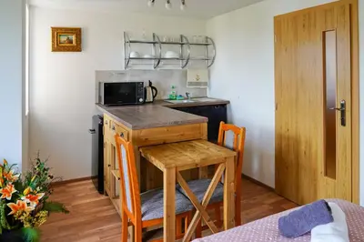 a small kitchen with a table and a microwave at Apartmán Praha Břevnov in Prague