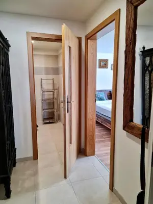 a hallway with an open door and a mirror at Apartmán Praha Břevnov in Prague