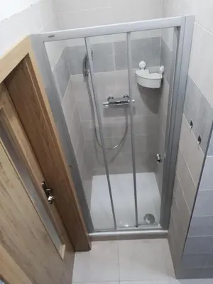 a shower with a glass door in a bathroom at Apartmán Praha Břevnov in Prague