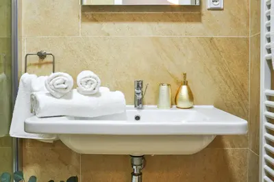 a white sink in a bathroom with towels at Residence Rybna 9- Old Town in Prague
