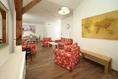 a waiting room with red chairs and a table at Unesco Prague Apartments in Prague