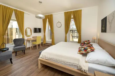 a bedroom with a bed and a desk and a chair at Unesco Prague Apartments in Prague