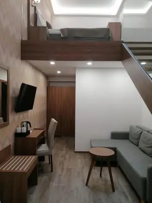 a living room with a couch and a desk and a tv at Hotel Prague Star in Prague