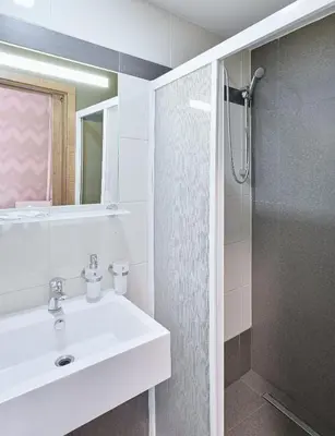 a white bathroom with a sink and a shower at Hotel Prague Star in Prague